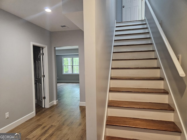 stairway featuring baseboards, wood finished floors, visible vents, and recessed lighting
