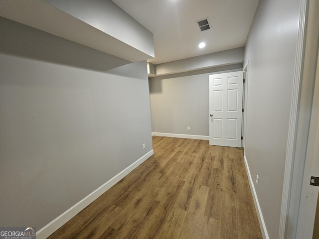 finished basement with baseboards, wood finished floors, visible vents, and recessed lighting