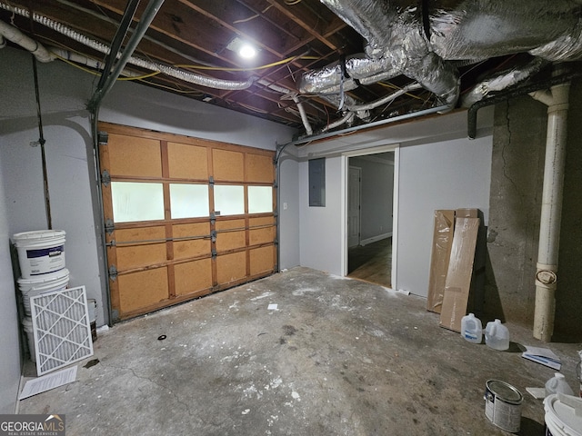 basement featuring electric panel and a garage