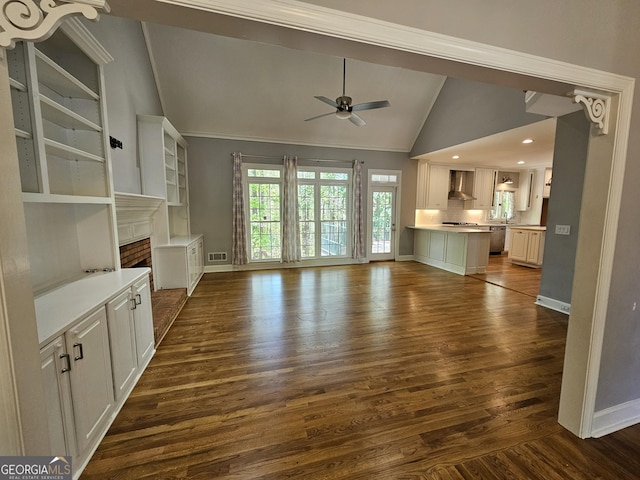 unfurnished living room with dark wood finished floors, baseboards, lofted ceiling, ceiling fan, and a fireplace