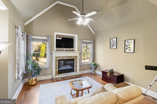 living room featuring a ceiling fan, a healthy amount of sunlight, wood finished floors, and a fireplace