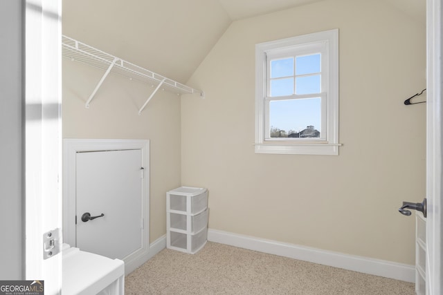 walk in closet with vaulted ceiling and carpet floors