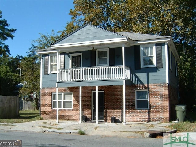 view of front of home featuring brick siding, a porch, ceiling fan, and fence