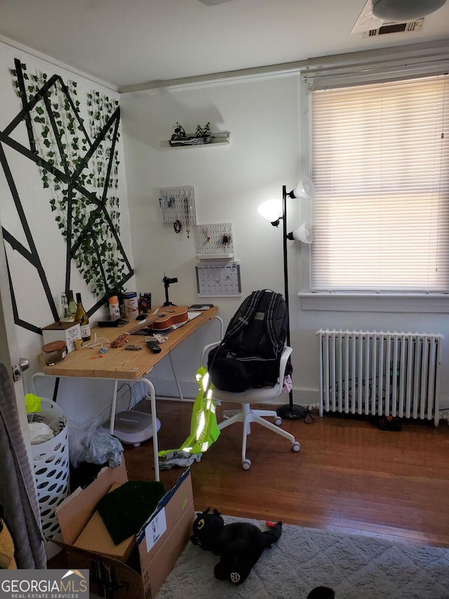 office with radiator, wood finished floors, visible vents, and baseboards