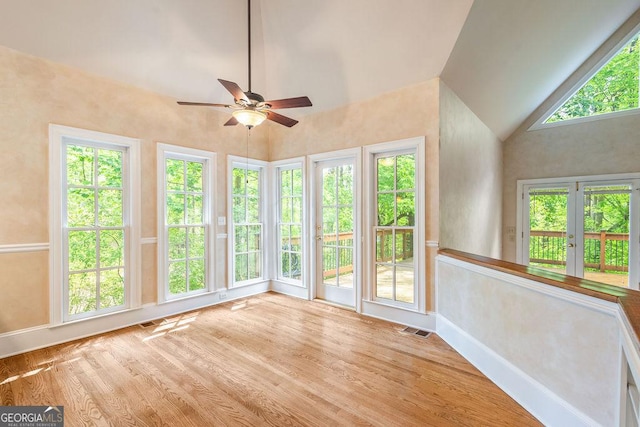 unfurnished sunroom with high vaulted ceiling, french doors, wood finished floors, and visible vents