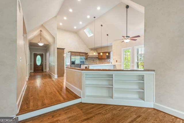 kitchen featuring stainless steel refrigerator with ice dispenser, high vaulted ceiling, open shelves, and light wood-type flooring