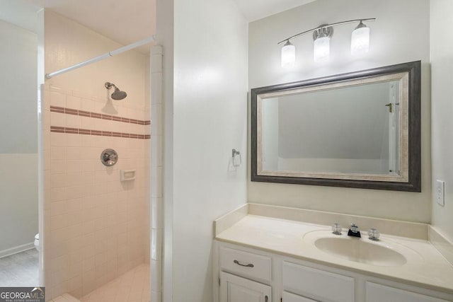 bathroom with toilet, a shower stall, and vanity
