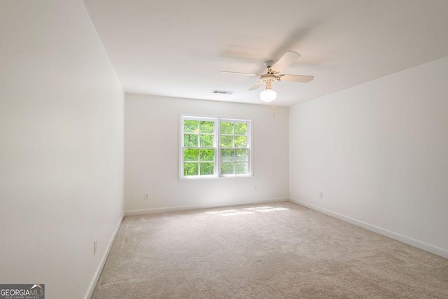 carpeted empty room featuring baseboards, ceiling fan, and visible vents