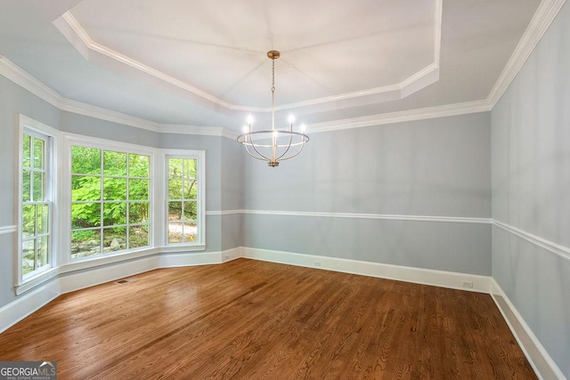 unfurnished dining area with baseboards, a notable chandelier, wood finished floors, and a raised ceiling