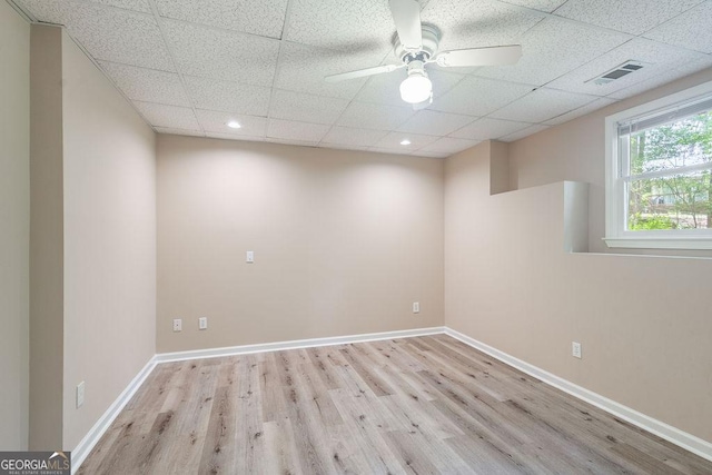 basement with baseboards, visible vents, wood finished floors, and a paneled ceiling