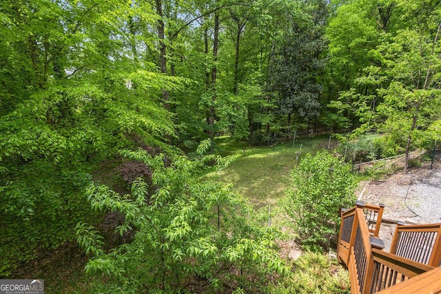 view of yard with a view of trees and a wooden deck