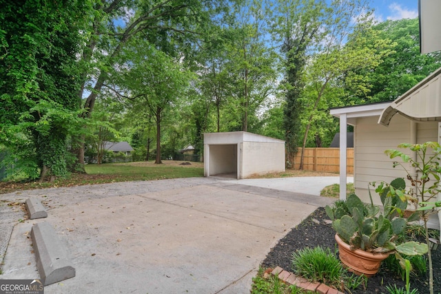 26 Walker St, Cartersville, GA 30120 - view of patio featuring a carport, fence, an outbuilding, and concrete driveway