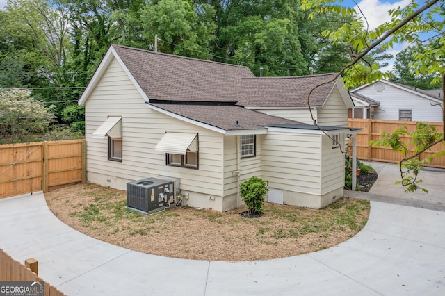 26 Walker St, Cartersville, GA 30120 - view of side of home featuring a fenced backyard, roof with shingles, and central AC