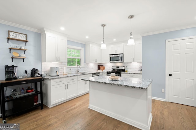 57 Glenn Eagles Way, Hiram, GA 30141 - kitchen with stainless steel appliances, a sink, white cabinets, ornamental molding, and light wood finished floors