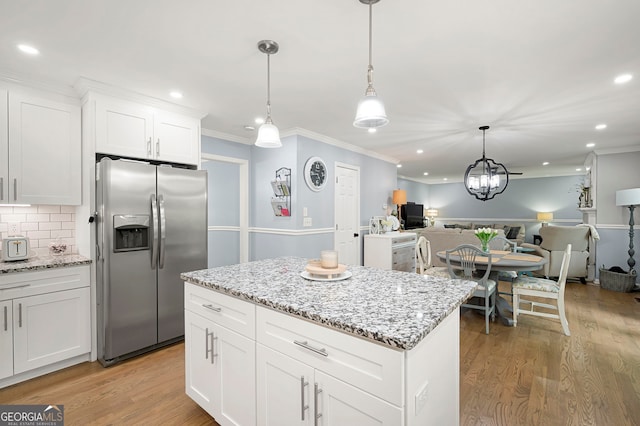 kitchen with stainless steel fridge with ice dispenser, open floor plan, ornamental molding, recessed lighting, and light wood-style floors