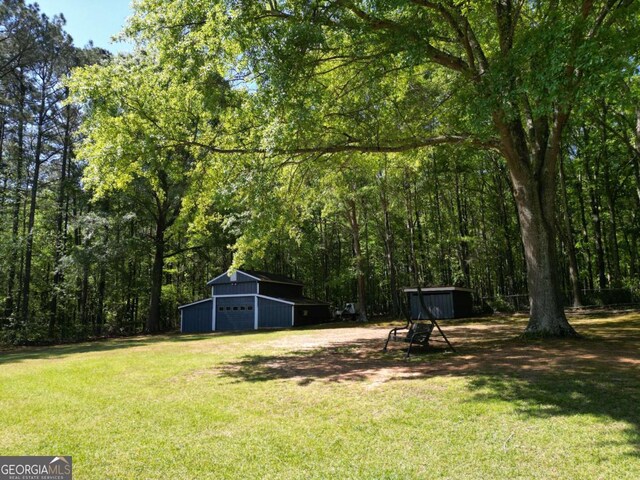 1961 Mars Hill Rd, Watkinsville, GA 30677 - view of yard with a garage, a forest view, and an outbuilding