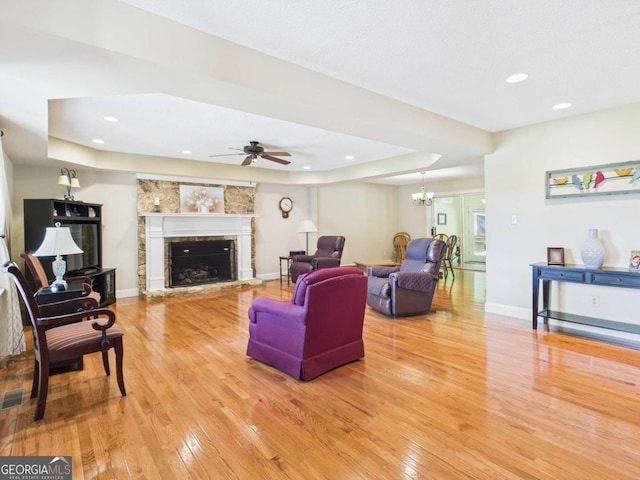 1961 Mars Hill Rd, Watkinsville, GA 30677 - living area featuring a fireplace with raised hearth, a raised ceiling, light wood-style floors, and ceiling fan with notable chandelier