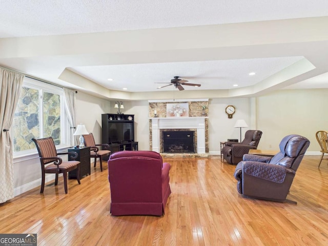 1961 Mars Hill Rd, Watkinsville, GA 30677 - living room with light wood-type flooring, baseboards, a fireplace with raised hearth, ceiling fan, and a raised ceiling