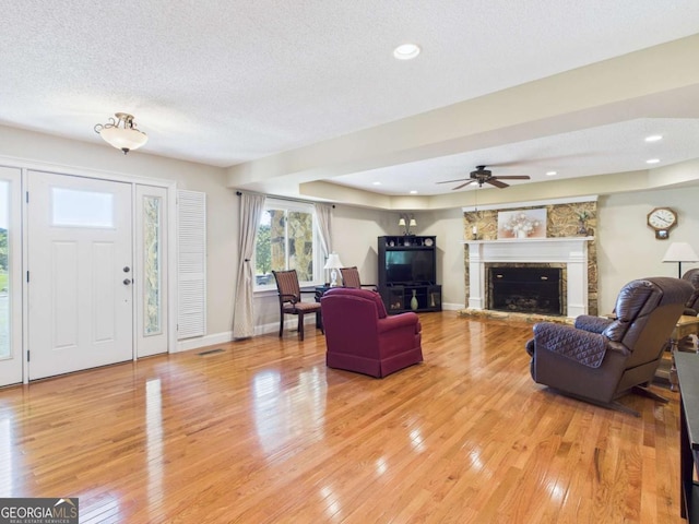 1961 Mars Hill Rd, Watkinsville, GA 30677 - living area with a stone fireplace, visible vents, a ceiling fan, light wood-style floors, and a textured ceiling