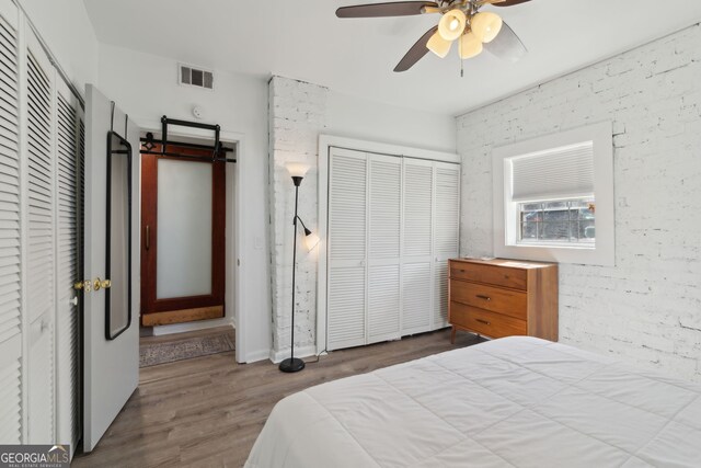 bedroom featuring ceiling fan, wood finished floors, and visible vents