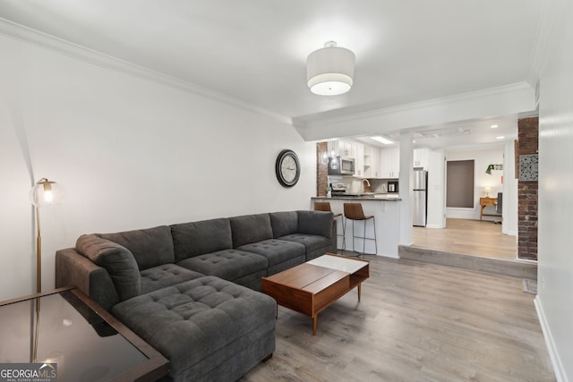 living room featuring light wood-style flooring, baseboards, and ornamental molding