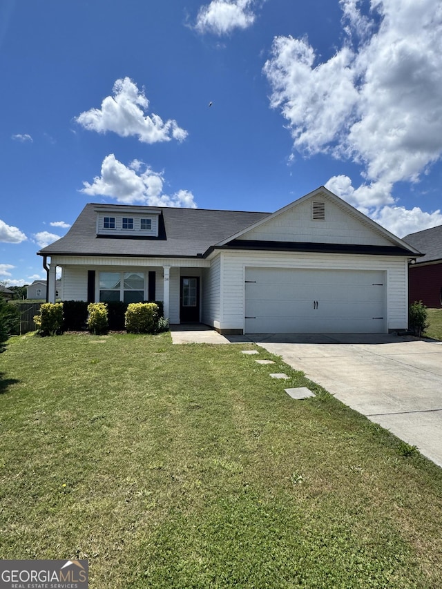 view of front of property featuring a front yard, a porch, driveway, and a garage