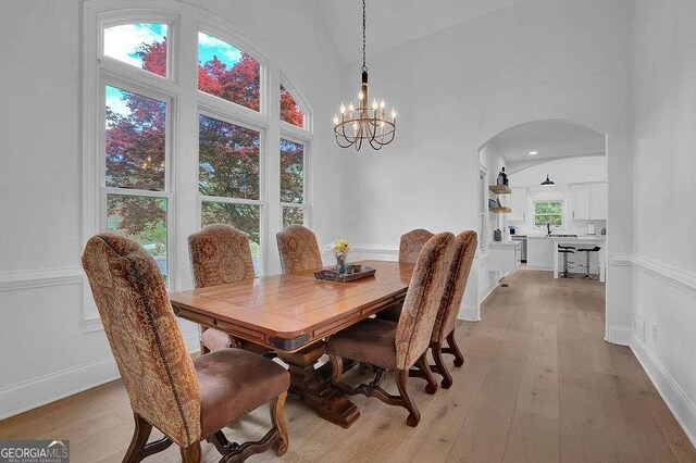3060 Cabernet Ct, Cumming, GA 30041 - dining area with arched walkways, light wood-type flooring, and a chandelier
