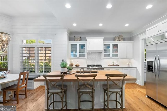 4675 Lakeway Pl, Alpharetta, GA 30005 - kitchen with light wood-type flooring, white cabinetry, built in refrigerator, wood counters, and premium range hood
