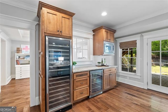 4675 Lakeway Pl, Alpharetta, GA 30005 - bar featuring stainless steel microwave, ornamental molding, beverage cooler, and wood finished floors