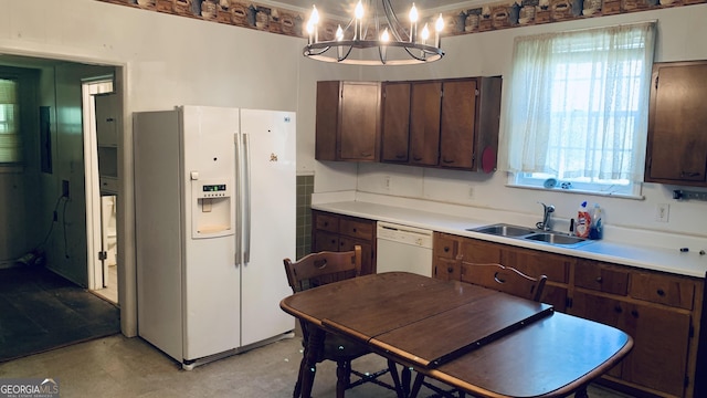kitchen featuring light countertops, plenty of natural light, a sink, and white appliances
