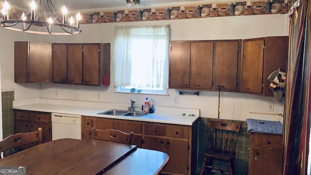 kitchen featuring a notable chandelier, white dishwasher, a sink, and light countertops