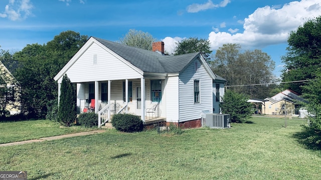 view of front facade featuring a chimney, a front lawn, central AC, crawl space, and a porch
