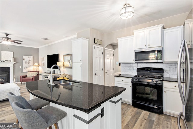 4440 Spring Mtn Ln, Powder Springs, GA 30127 - kitchen with white cabinetry, a sink, stainless steel appliances, open floor plan, and a ceiling fan