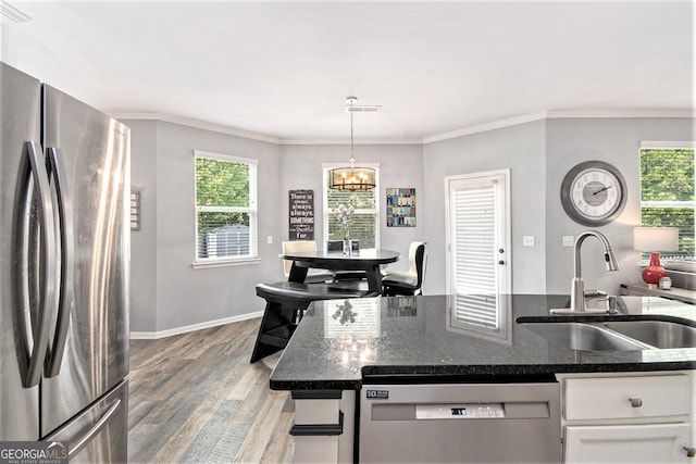 4440 Spring Mtn Ln, Powder Springs, GA 30127 - kitchen with stainless steel appliances, light wood-style flooring, white cabinetry, a chandelier, and crown molding