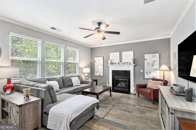 4440 Spring Mtn Ln, Powder Springs, GA 30127 - living area featuring a ceiling fan, wood finished floors, a fireplace with flush hearth, and ornamental molding