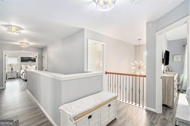 4440 Spring Mtn Ln, Powder Springs, GA 30127 - hallway featuring wood finished floors, a chandelier, an upstairs landing, and attic access