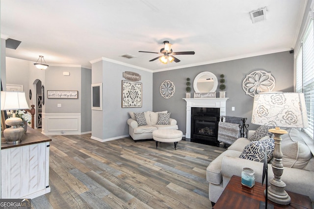 4440 Spring Mtn Ln, Powder Springs, GA 30127 - living area with a ceiling fan, wood finished floors, a glass covered fireplace, crown molding, and arched walkways