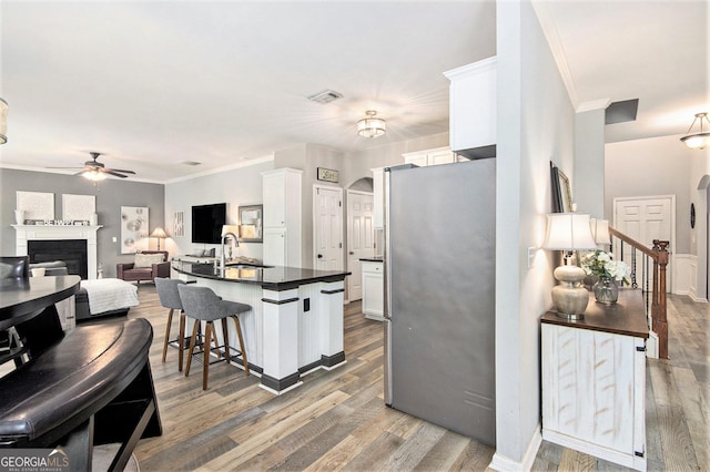 4440 Spring Mtn Ln, Powder Springs, GA 30127 - kitchen featuring freestanding refrigerator, a ceiling fan, dark countertops, white cabinets, and light wood-style flooring