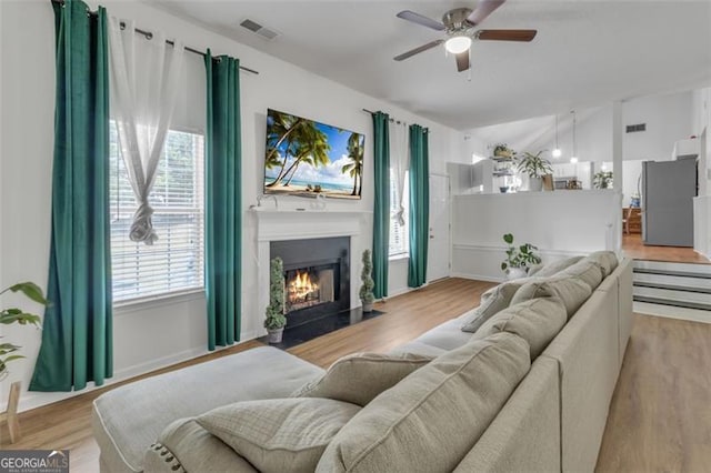 831 Kendall Park Dr, Winder, GA 30680 - living area featuring ceiling fan, wood finished floors, and a fireplace with flush hearth