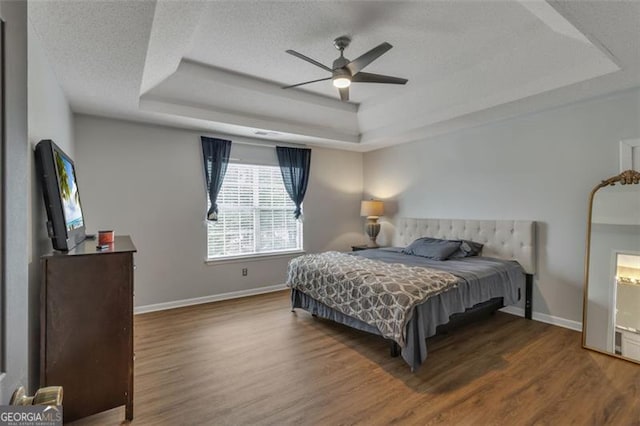 831 Kendall Park Dr, Winder, GA 30680 - bedroom with a raised ceiling, baseboards, a textured ceiling, wood finished floors, and a ceiling fan