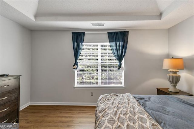 831 Kendall Park Dr, Winder, GA 30680 - bedroom with a raised ceiling, wood finished floors, baseboards, and a textured ceiling