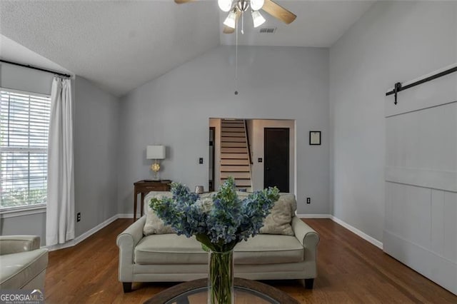 831 Kendall Park Dr, Winder, GA 30680 - sitting room featuring ceiling fan, stairway, wood finished floors, vaulted ceiling, and a barn door