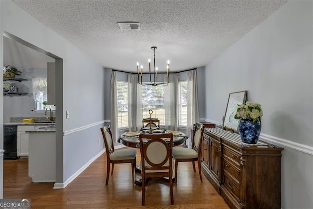 831 Kendall Park Dr, Winder, GA 30680 - dining space featuring a chandelier, a textured ceiling, wood finished floors, and baseboards