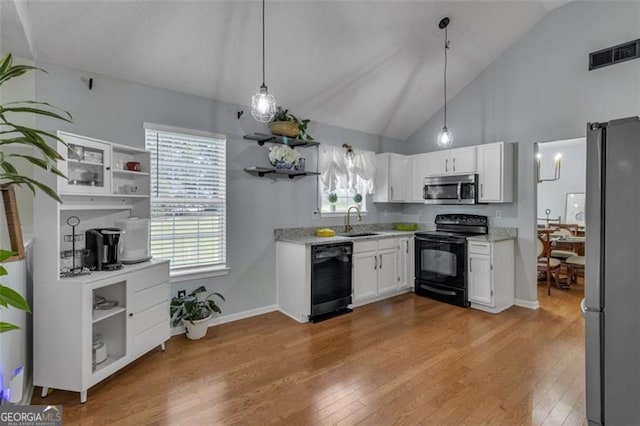 831 Kendall Park Dr, Winder, GA 30680 - kitchen with black appliances, open shelves, a sink, vaulted ceiling, and white cabinets