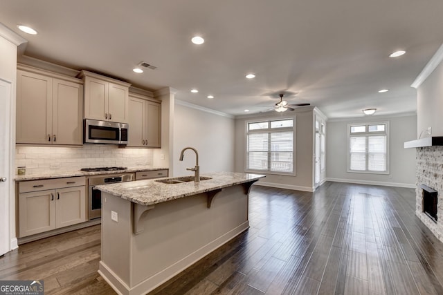 kitchen with stainless steel appliances, a sink, visible vents, ceiling fan, and crown molding