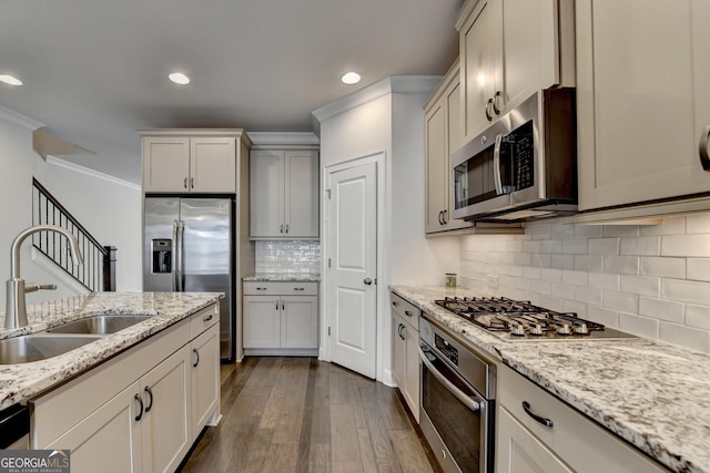 kitchen with a sink, recessed lighting, decorative backsplash, dark wood-type flooring, and appliances with stainless steel finishes