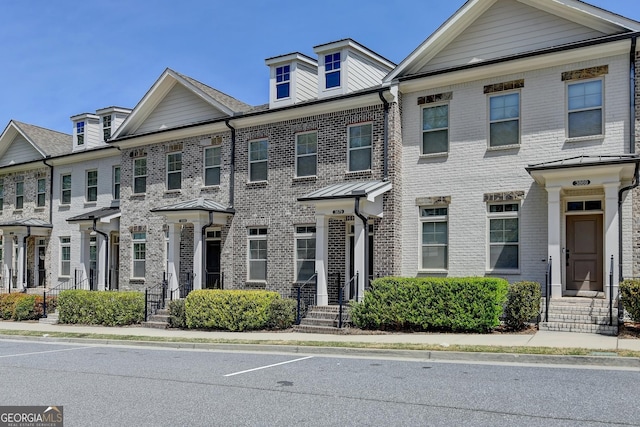 townhome / multi-family property featuring brick siding