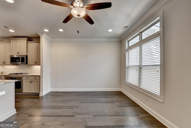 kitchen with decorative backsplash, ornamental molding, stainless steel appliances, and visible vents