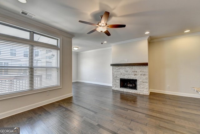 unfurnished living room with a stone fireplace, visible vents, a ceiling fan, crown molding, and baseboards