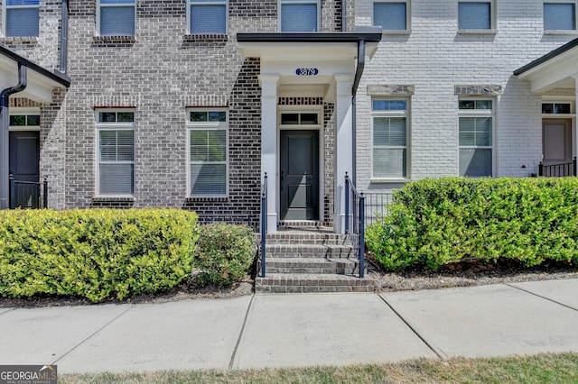 doorway to property featuring brick siding
